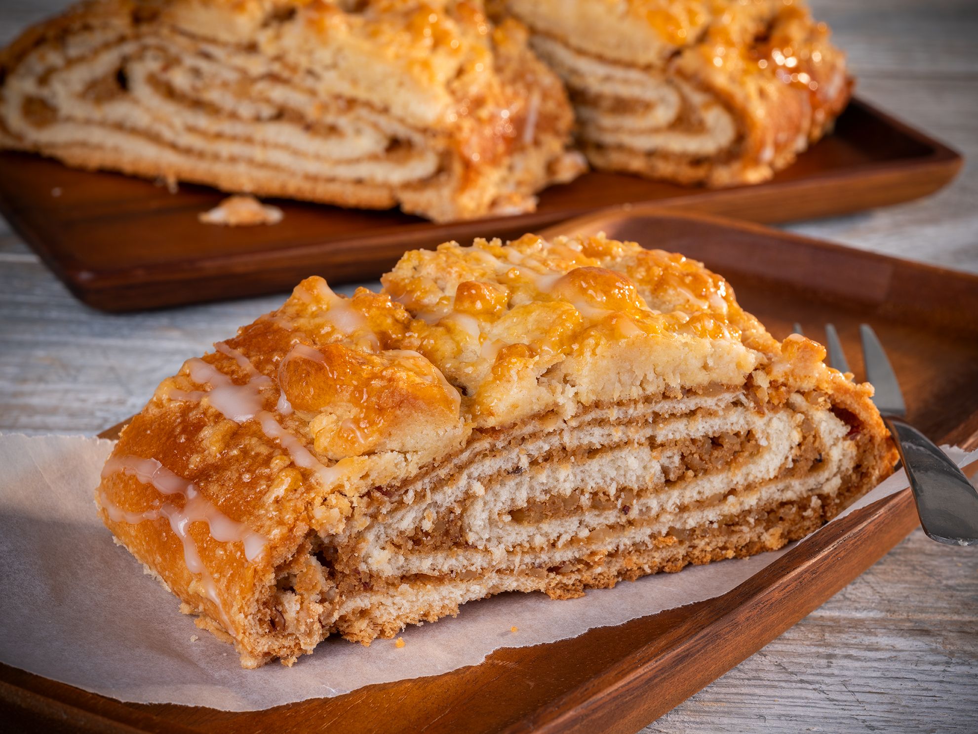 Bäcker Müller Produkte Gebäck & Süßes: Nussstrudelstück auf Holzbrett mit Gäbelchen