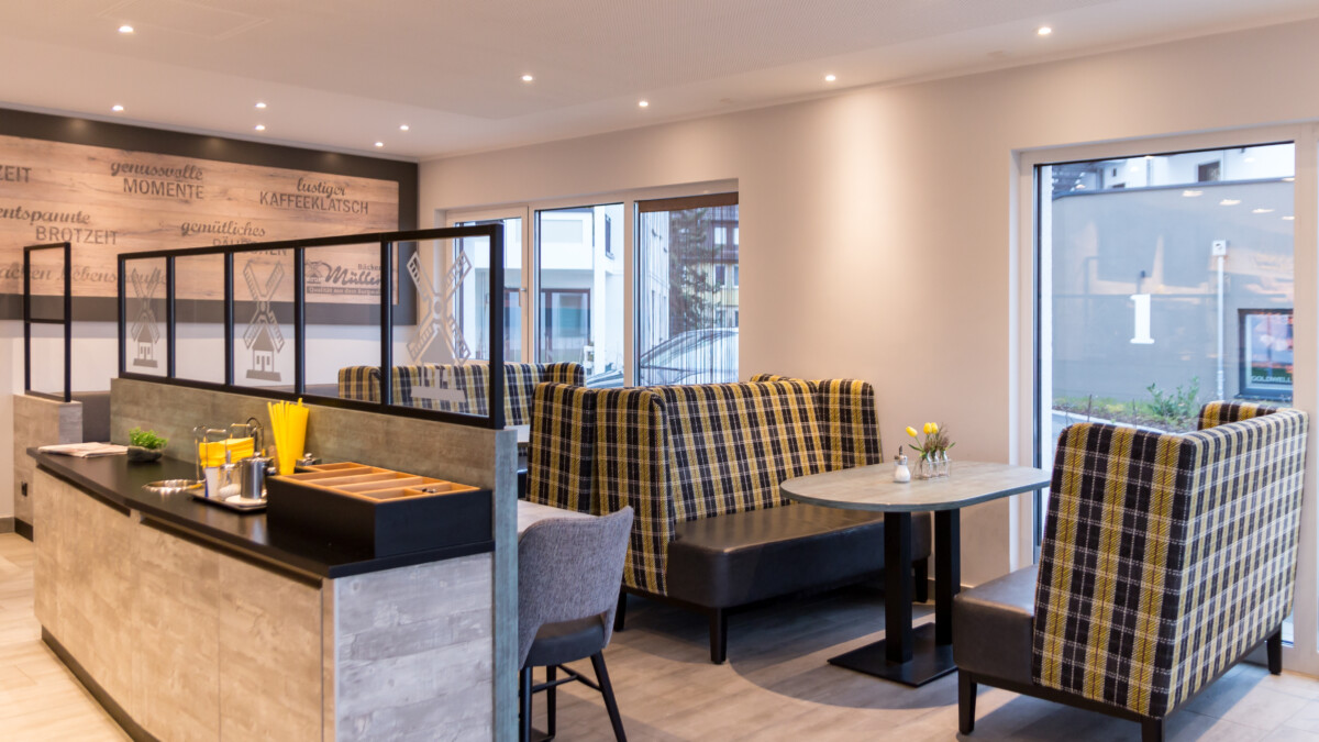 Bäcker Müller, Filiale in Gießen/Aluweg, Ulner Dreieck, Ansicht Cafe-Bereich mit Sitzbänken, Stühlen und Tischen