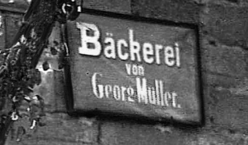 Bäcker Müller, Bild mit dem alten Müller Bäckerei-Schild auf der Hauswand